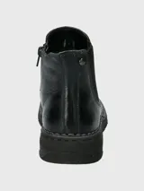 Bota tipo Chelsea de cuero negro, con paneles laterales elásticos y suela de goma flexible con costura vista en el borde.