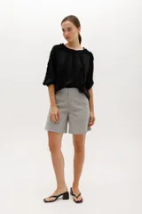 Blusa blanca de algodón suave, con mangas 3/4 y escote redondo con volados en el frente, mangas y escote.