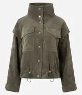 Campera de pana cotelé color verde militar, con cuello camisero, cierre frontal con botones metálicos y bolsillos frontales con solapa. Presenta diseño de sisa desplazada y cordones ajustables en el ruedo.