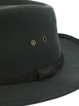 Sombrero tipo fedora de color verde oscuro, confeccionado en canvas engrasado resistente al agua. Presenta una cinta trenzada decorativa en la base de la copa y detalles de ojales metálicos laterales.
