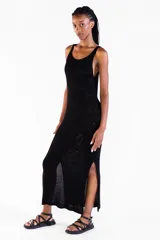 Vestido largo negro de punto con hilo lurex brillante, sin mangas, con escote redondo y aberturas laterales.