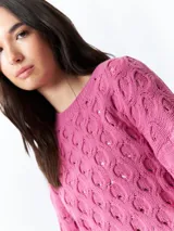 Sweater color crema tramado de manga larga y cuello redondo.