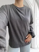 Remera gris topo de tejido acanalado, corte recto y mangas largas.