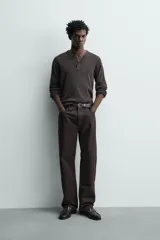 Jeans flare fit de denim negro, con tiro medio, corte ajustado en la parte superior y ligeramente acampanado desde la rodilla. Diseño de cinco bolsillos y cierre frontal con botones.