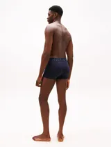 Pack de tres calzoncillos tipo trunk de algodón elástico. Cada uno presenta una cintura elástica distintiva con el logo de Tommy Hilfiger en contraste.