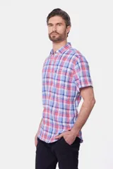 Camisa de lino de manga corta con estampa a cuadros en tonos rosado, celeste y blanco, con cuello camisero y cierre frontal de botones.