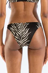 Bombacha de bikini con estampado animal print tipo cebra en tonos negro y beige, confeccionada en jacquard. Cuenta con un aro metálico decorativo en el lateral de la cadera.