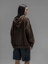 Hoodie oversize de algodón con efecto desgastado y oxidado. Presenta costuras expuestas, detalles de roturas en los bordes, capucha y bolsillo frontal tipo canguro.