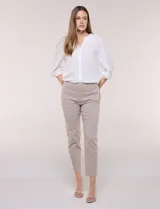 Pantalón de gabardina elastizada color beige, de tiro medio y calce slim. Cuenta con diseño pull-on sin cierres ni botones, cintura ancha, bolsillos delanteros simulados y bolsillos traseros ojal.