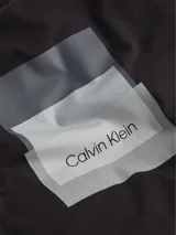 Remera de manga larga negra de algodón regenerado, con cuello redondo y logo de Calvin Klein estampado en el pecho.