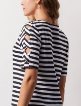 Remera de algodón a rayas horizontales blancas y negras, con cuello redondo y mangas cortas con aberturas entrelazadas.
