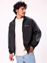 Campera rompevientos Rusty de nylon, color azul con detalles en azul claro en las mangas. Presenta cierre frontal, cuello alto y puños elásticos.