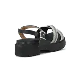 Sandalias de plataforma negra con suela dentada, tiras cruzadas en el empeine cubiertas de strass plateado y pulsera al tobillo con hebilla metálica.