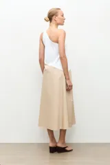 Maxi vestido largo de corte evasé, diseño bicolor con parte superior blanca y parte inferior beige, escote asimétrico de un solo hombro.