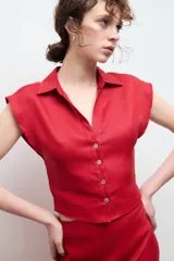 Camisa color beige claro de lino, con cuello clásico, abotonada al frente y sin mangas.