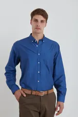 Camisa azul con microestampado de lunares blancos, de corte clásico, con cuello abotonado y manga larga.