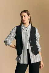 Camisa de manga larga con diseño de rayas verticales en tonos grises y blancos, cuello camisero y cierre frontal con botones.