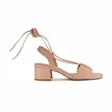 Sandalias de tacón color rosa nude, con tiras trenzadas y cierre con cordones para atar al tobillo.