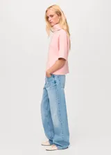 Jersey de punto color rosa, con cuello alto, manga corta y diseño recto.