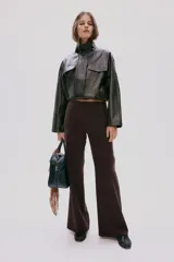 Pantalón sastrero de color marrón oscuro, con diseño de perneras amplias y rectas, de tiro medio con bolsillos decorativos insertados en la parte delantera.