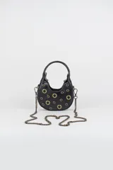 Cartera mini hobo estructurada de cuero negro, decorada con arandelas metálicas doradas en toda la superficie. Cuenta con asa corta de mano y correa de cadena metálica extraíble.