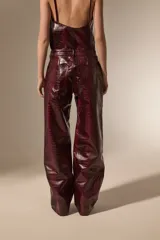 Pantalon de corte recto con diseño de estampado de piel de serpiente, confeccionado en cuero sintético (PU). Presenta bolsillos laterales y cierre frontal con botón.