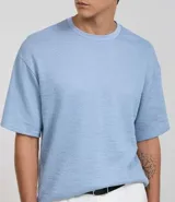 Remera celeste de algodón texturizado, corte boxy, cuello redondo y manga corta.
