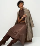 Vestido midi marrón de viscosa, sin mangas, con cuello cerrado y cintura con recorte asimétrico.