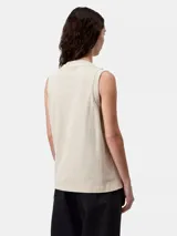 Musculosa Carhartt WIP modelo Nelson, color beige, con cuello redondo, corte holgado y pequeña etiqueta cuadrada tejida con el logo en el pecho.
