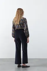 Pantalón de pana color marrón chocolate, de corte recto con bolsillos laterales y cierre frontal.