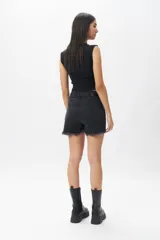 Short de jean azul con terminación desflecada, tiro alto, cuatro bolsillos y pequeña abertura en ambos laterales.