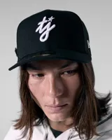 Gorra snapback negra, estilo 59FIFTY, con visera plana y bordado frontal en hilo blanco que simula las letras 'tj' con una estrella.