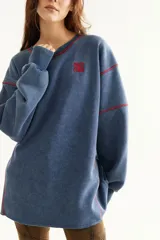 Buzo de algodón marrón con efecto acid wash, cuello redondo, mangas largas y forro interno de polar. Cuenta con costuras decorativas y bordado azul en el pecho.