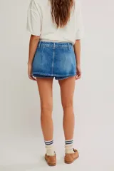 Falda pantalón de denim azul con tiro bajo, diseño cruzado al frente y short interno.