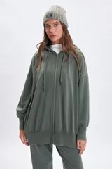 Campera deportiva de corte oversize con cierre frontal completo, capucha con cordones ajustables y puños elásticos. Presenta un acabado con efecto lavado en color verde.