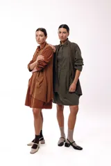 Vestido camisero de silueta amplia y fluida, color verde militar, con cuello camisero, frente abotonado parcial, mangas largas y bolsillos laterales.