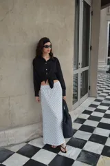 Pollera larga de viscosa, color azul marino con estampado de lunares blancos. Diseño de tiro alto y corte amplio.