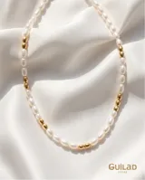 Collar de acero con baño de oro, compuesto por una alternancia de perlas de río y pequeñas cuentas doradas.