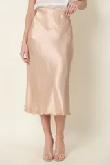Pollera midi color champagne de satén de seda, con cintura elastizada y corte evasé.