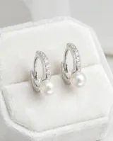 Aros colgantes de plata 925 con diseño de argolla pequeña decorada con circonias y una perla blanca colgante.