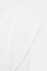 Top blanco de tejido de punto elástico, con escote asimétrico y una manga corta.