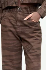 Jean flare de tiro alto con estampado animal print en tonos marrón, diseño clásico de cinco bolsillos y corte recto.