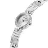 Reloj analógico Guess modelo Holly con caja redonda de 23mm y correa tipo brazalete de acero inoxidable en tono plateado. La esfera presenta un acabado radiante con índices de cristales y bisel decorado con textura de cuentas.