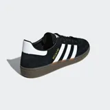 Championes Adidas Handball Spezial negros con detalles en blanco y suela de goma color caramelo.