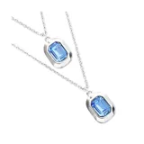 Collar doble de cadena fina bañado en plata, con dos dijes rectangulares que contienen cristales facetados en color azul.