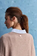 Sweater blanco de punto con diseño holgado, cuello redondo, mangas largas acampanadas y detalles de textura horizontal en el tejido.