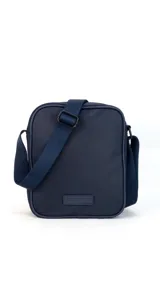 Morral de tela impermeable color negro, de forma rectangular y diseño compacto. Cuenta con correa ajustable para llevar al hombro o cruzado, y múltiples compartimentos con cierre, incluyendo un bolsillo frontal vertical con cierre.