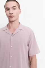 Camisa blanca de manga corta con textura, fit regular y logo bordado.