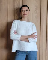 Sweater de punto color blanco con textura tipo waffle, corte holgado y mangas largas.