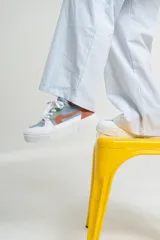 Zapatillas bajas color beige y marrón, con cordones y suela blanca.